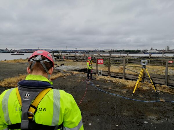 surveyors on old jetty structure with safety harnesses and ropes