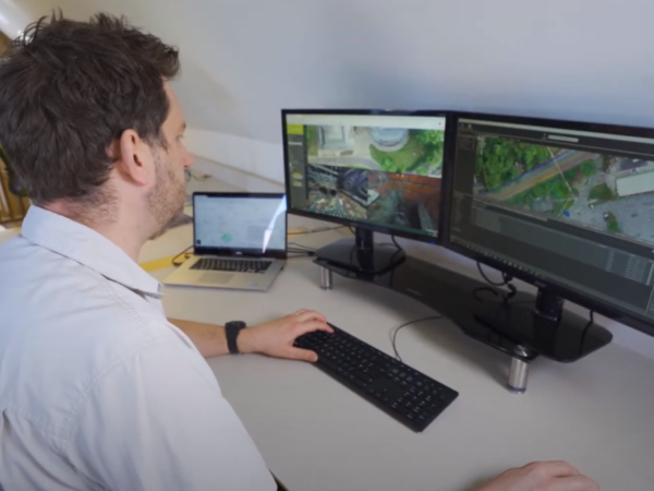 side on image of office worker at desk reviewing data on screen